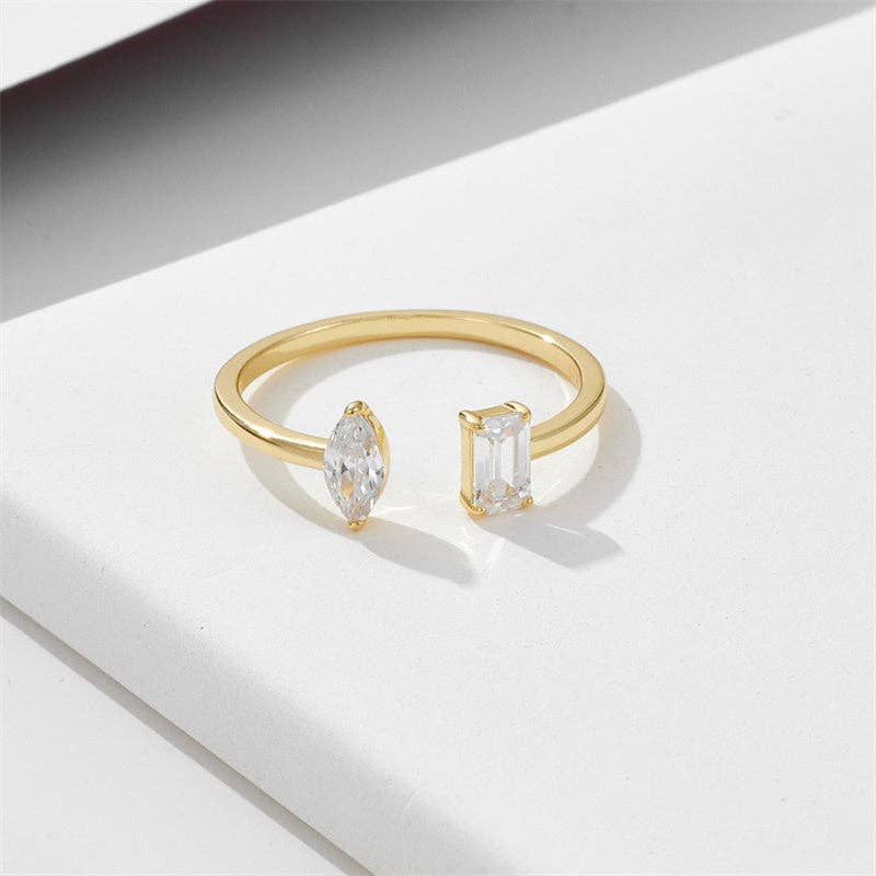 Gold ring with two diamond stones on a light background