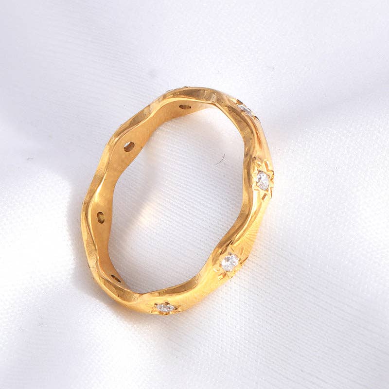 Gold ring with diamond accents on a white background